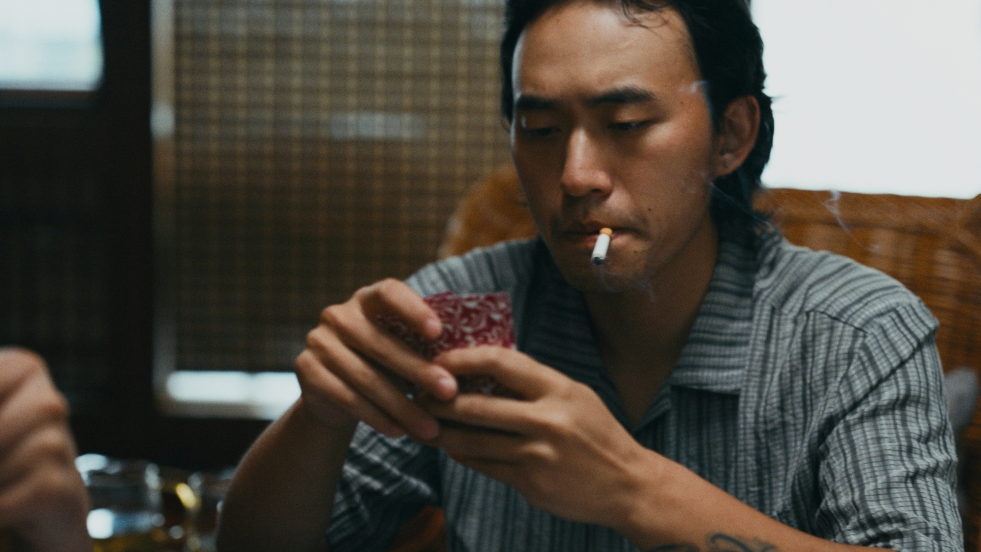 室内拿着纸牌的男子
